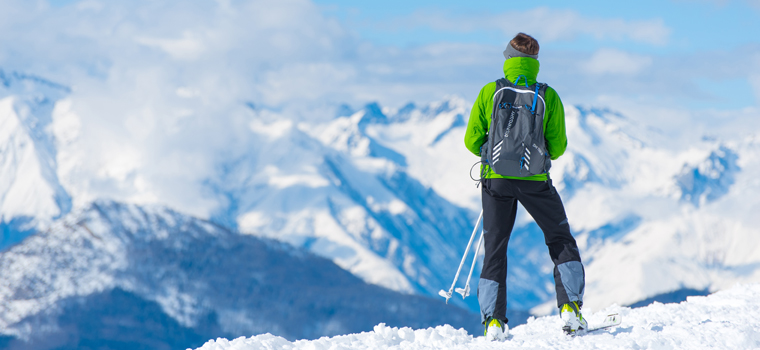 Gafas de esquí de un hombre con el reflejo de las montañas fondo